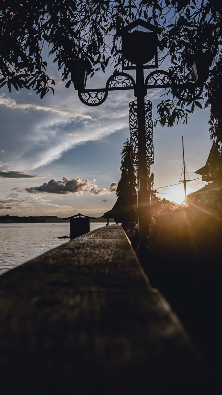 sky, water, nature, morning, reflection, light, sunlight, tree, cloud, beauty in nature, darkness, scenics - nature, sea, tranquility, beach, plant, no people, land, silhouette, tranquil scene, dusk, outdoors, architecture, travel destinations, sun, transportation, horizon, idyllic