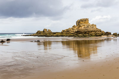 Rocks on beach against sky