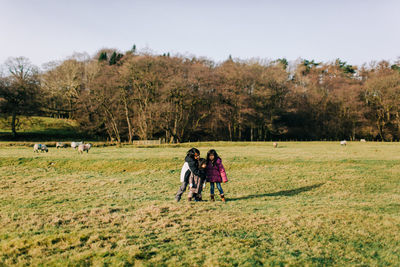 Rear view of people walking on field