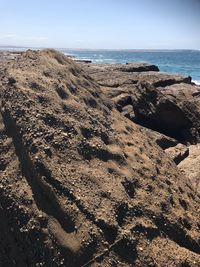 Scenic view of rocks on beach against sky