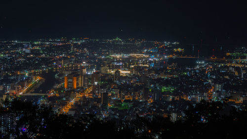 High angle view of illuminated city against sky at night