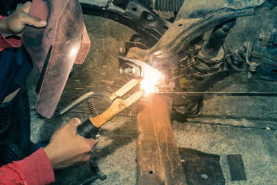 Midsection of man working on metal