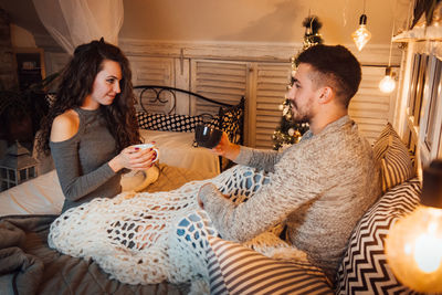 Happy friends sitting on sofa