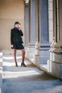 Young woman smoking while standing at corridor