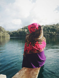 Rear view of woman in lake against sky