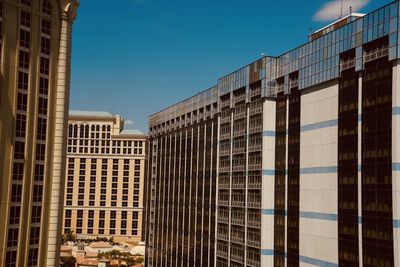 Low angle view of modern buildings against clear blue sky