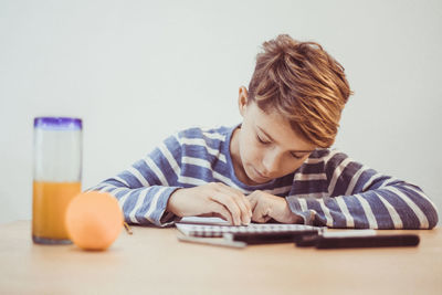 Boy making sketch on note pad at table