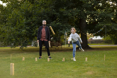 Father and daughter playing molkky game in park