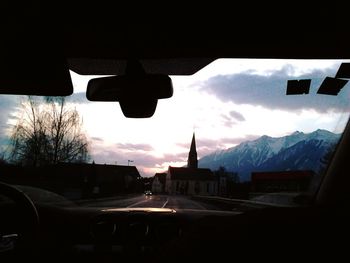 Silhouette cars on road against sky