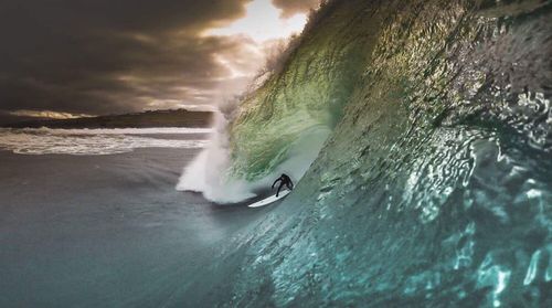 Man surfing in sea against sky