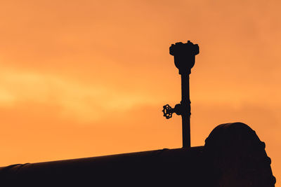 Silhouette cross against sky during sunset