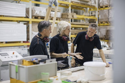 Female workers discussing with colleague while working at industry