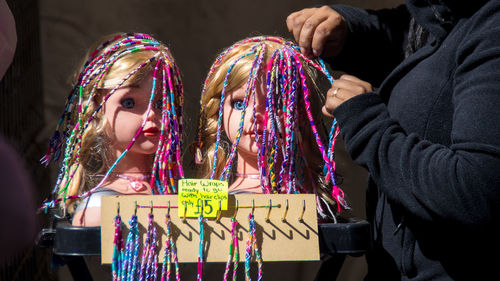 Close-up of two doll heads with beaded hair