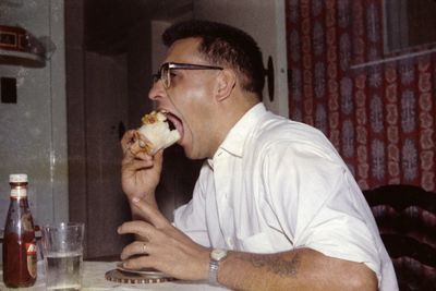 Side view of a man eating food