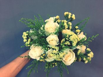 Close-up of hand holding rose bouquet