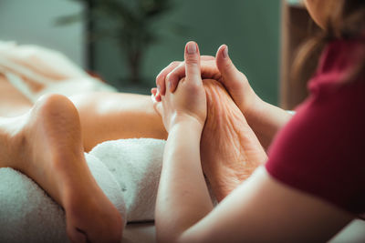 Relaxing foot massage, hands of a female massage therapist massaging 