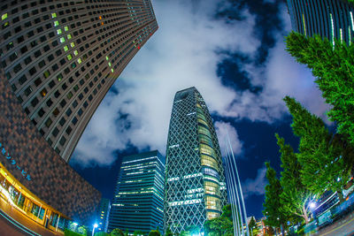 Low angle view of modern buildings against cloudy sky