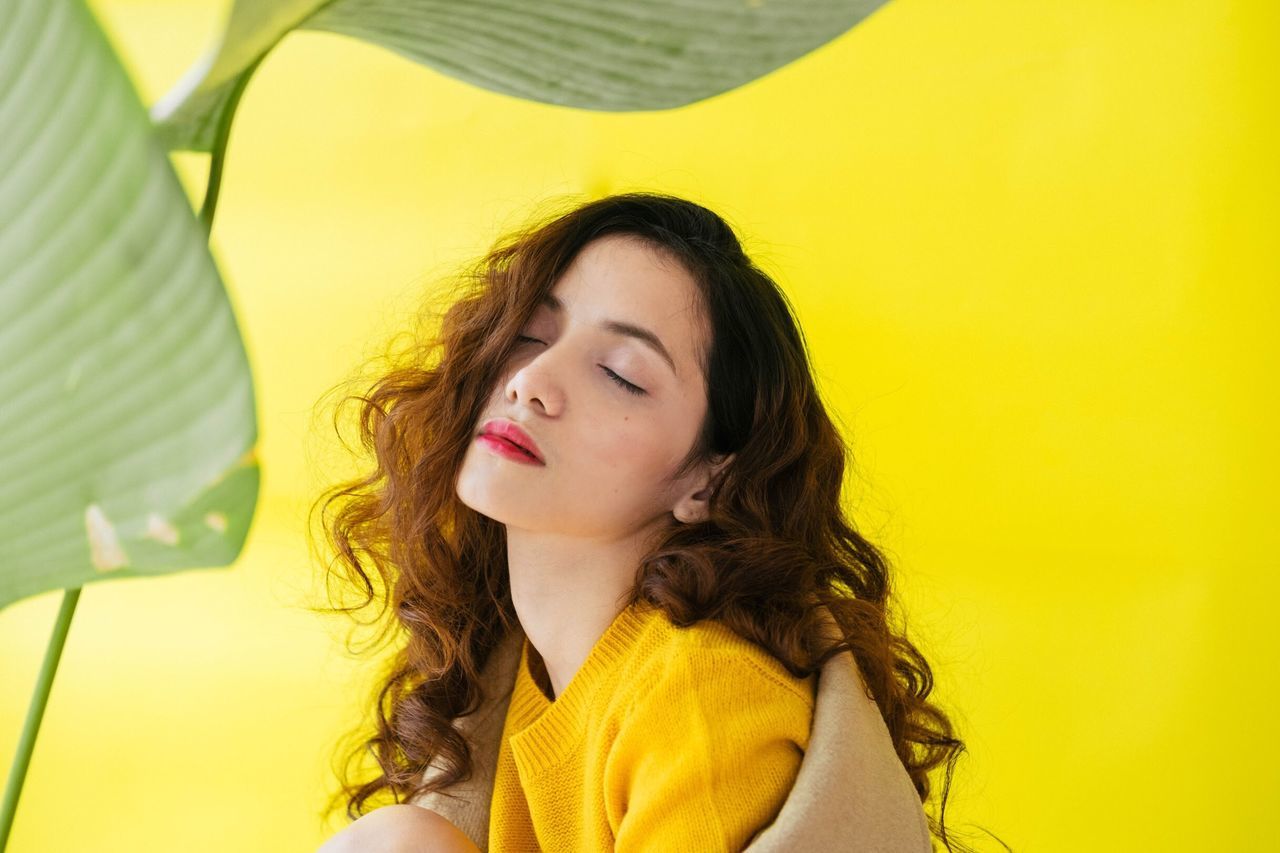 yellow, one person, brown hair, eyes closed, headshot, yellow background, one young woman only, young adult, colored background, one woman only, beauty, day, beautiful people, portrait, only women, beautiful woman, close-up, outdoors, people, young women, adults only, adult