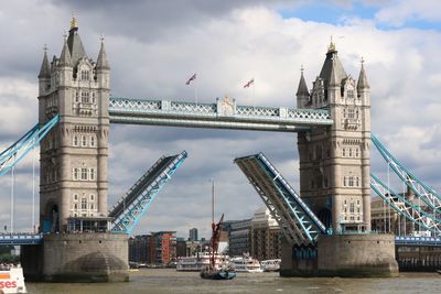 Tower bridge against cloudy sky