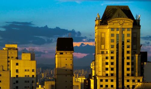 Buildings in city at sunset