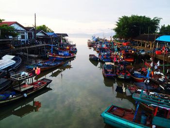 High angle view of fishing boats moored at canal against sky