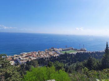 Aerial view of townscape by sea against sky 