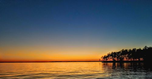 Scenic view of sea against clear sky during sunset