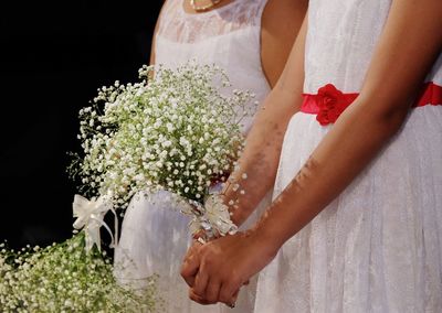 Midsection of woman holding flower bouquet