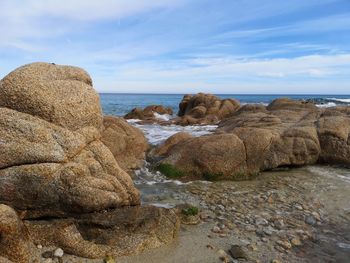 Rocks on beach against sky