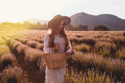 Full length of woman standing on field against sky