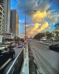 Road passing through city at sunset