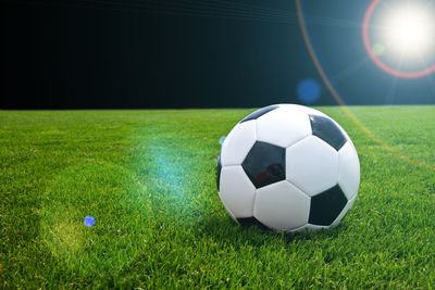 Close-up of soccer ball on field at night