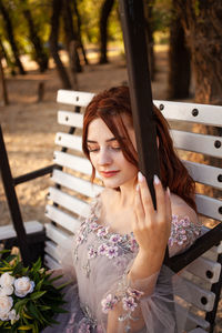 Portrait of young woman sitting outdoors