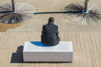 Rear view of a man sitting outdoors