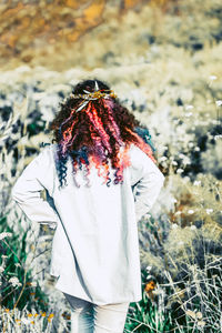 Rear view of woman standing against plants