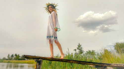 Woman standing by plants against sky