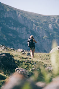 Rear view of female hiker standing on mountain