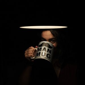 Portrait of mid adult woman having drink while standing in darkroom