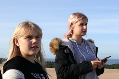 Siblings standing on man looking at view