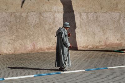 Rear view of man standing against wall