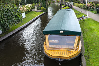 A wooden excursion boat moored in the channel, visible stern of the ship.