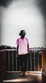 Full length of man standing by railing against sky