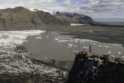 Scenic view of lake by mountains against sky