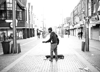 Rear view of man walking on street in city