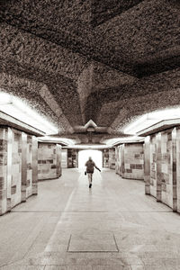 Rear view of man walking in subway station