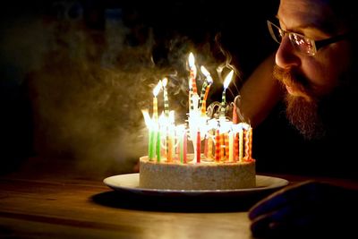 Man blowing candles on birthday cake