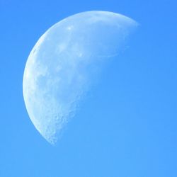 Low angle view of moon against blue sky