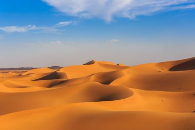 Sand dunes in desert against sky