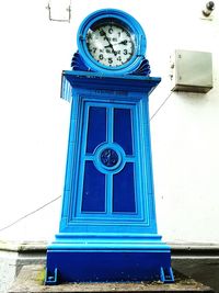 Low angle view of clock against blue sky