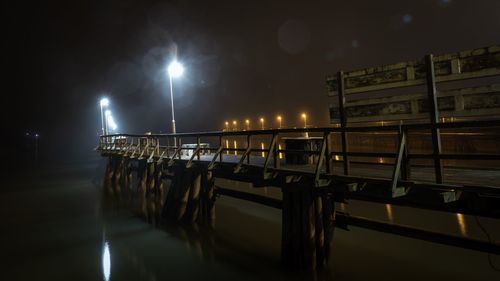 View of pier in canal at night